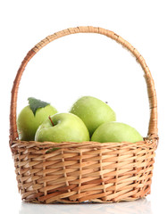 Ripe green apples with leaves in basket isolated on white