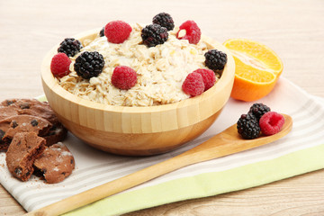 tasty oatmeal with berries, on wooden table