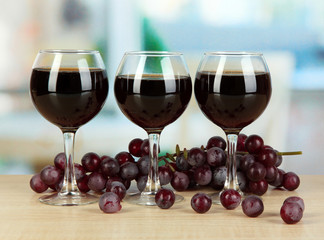 Red wine in glass on room background