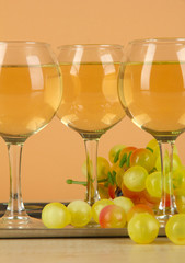 White wine in glass on salver on beige background
