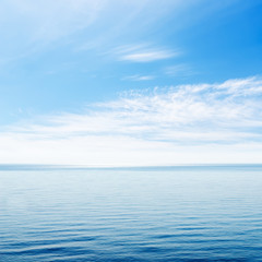 blue sea and cloudy sky over it