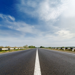 road closeup under cloudy blue sky