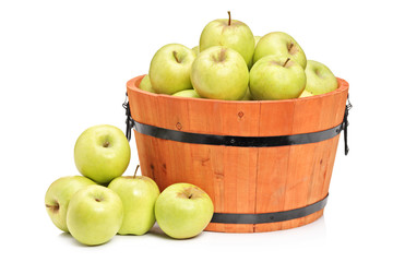 A studio shot of green apples in a wooden basket