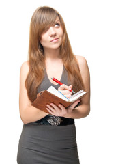 Cute young woman with pen and datebook deep in thought