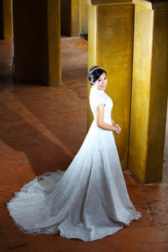 Romantic portrait of the beautiful bride near pillars