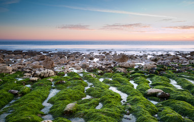 Beautiful sunset over Summer ocean with rocks and vibrant colors