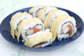 Crab and salmon sushi with a layer of egg