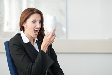 Junge Geschäftsfrau schreit ins Telefon