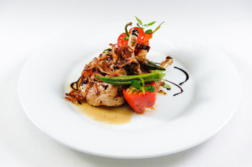 Juicy lamb steak with vegetables on a plate close-up