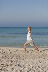 Mann macht yoga Sport am Strand Hochformat