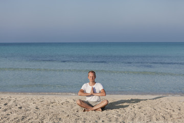 Mann macht yoga Sport am Strand Querformat