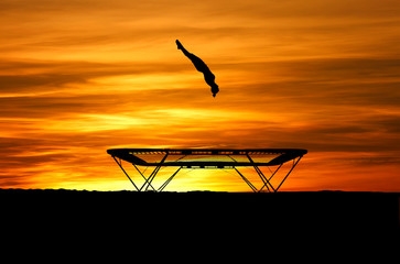 silhouette of trampoline gymnast in sunset