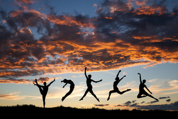 silhouette of dancers in sunset sky - 45611153