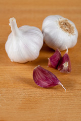Dos ajos con dientes sueltos aislados en madera
