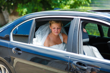 blonde bride at a wedding sitting in a car