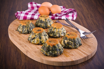 Spinach cakes on wooden cutting board.