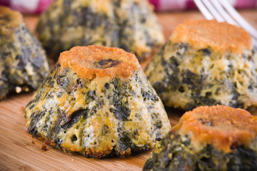 Spinach cakes on wooden cutting board.