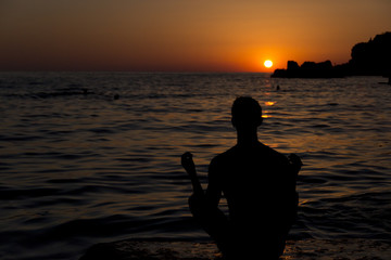 Man meditating at sunset
