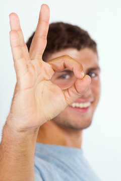 Young man doing the ok sign on white background 