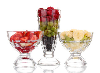 Mixed fruits and berries in glasses isolated on white