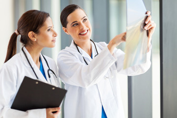 two female medical doctors looking at patient's x-ray
