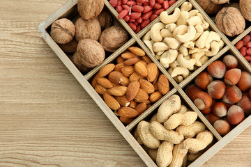 assortment of tasty nuts in  wooden box on table