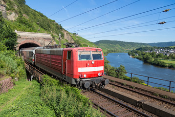 Obraz premium Train leaving a tunnel near the river Moselle in Germany