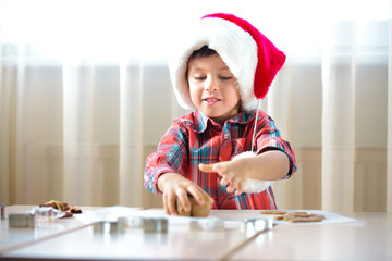 Little boy helping at kitchen with baking cookies