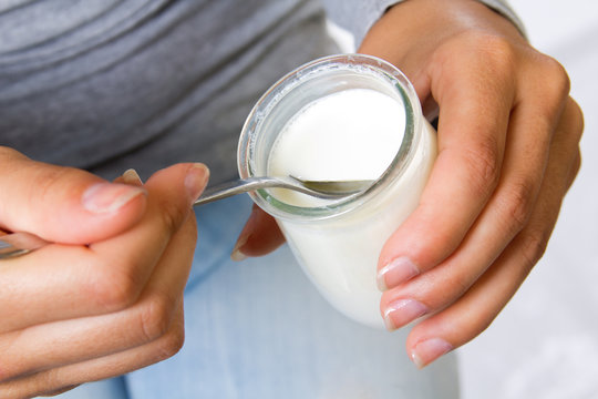 young woman at home eating yogurt 