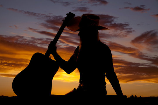 woman hold guitar at side silhouette