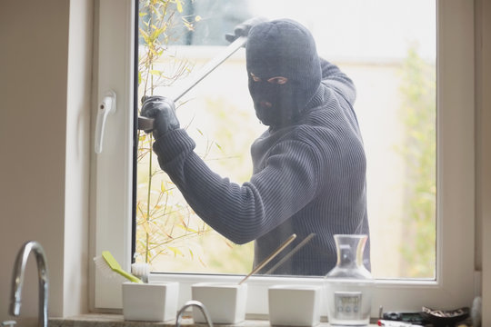Burglar breaking a kitchen window