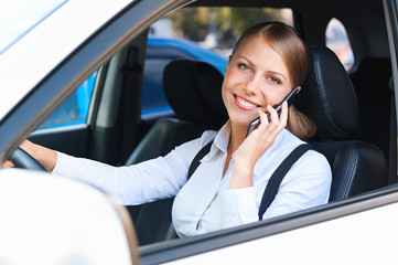 woman driving the car and talking on the phone