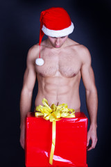 Portrait of a handsome muscular young man in Santa Claus hat