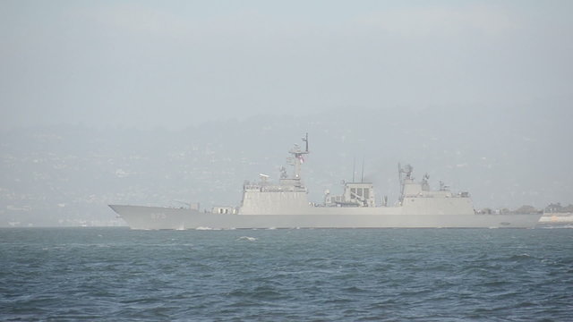 Modern military warship leaving port