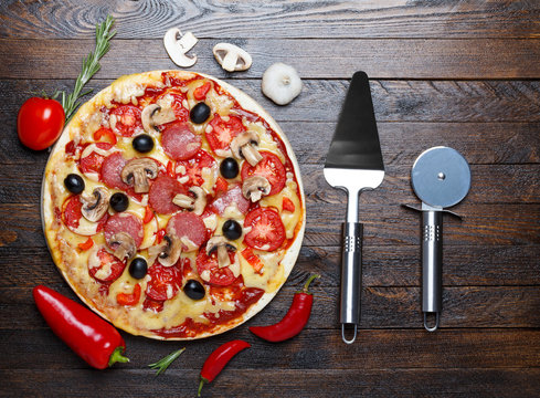 Pizza with ingredients and lifter, cutter