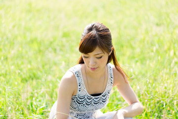 Beautiful young woman on green field