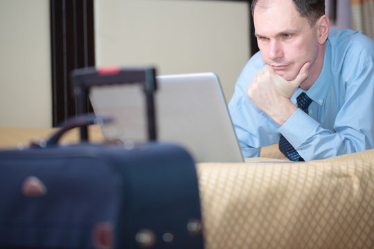 Businessman with laptop in a hotel room