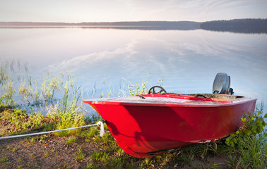 Red motorboat moored on the coast of Saimaa lake, Finland