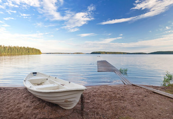 Coastal landscape with old white boat on the coast © evannovostro