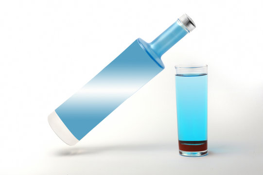 beyaz zemin &uuml;zerinde mavi vodka şişesi ve bardağı 