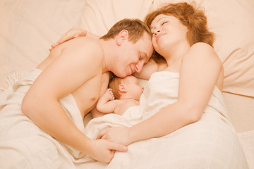 Obraz na płótnie Canvas family sleeping together, Mother, father and newborn