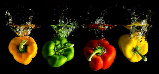 Foto op Plexiglas anti-reflex Bestsellers in de keuken vier verschillende gekleurde paprika& 39 s vallen in het water