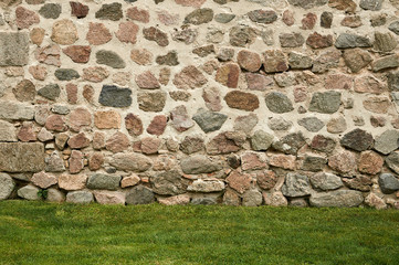 Background of stone wall and green grass