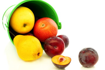 Summer fruits spilling from green bucket.