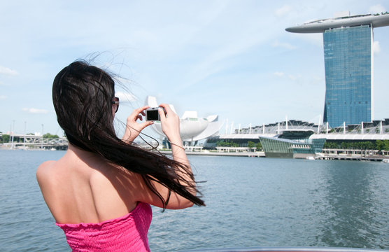 Young woman taking picture of Marina bay hotel in Singapore