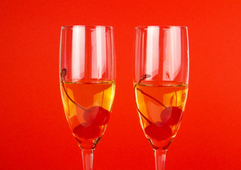 Two glasses of champagne on red background