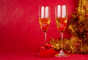 Two glasses of champagne on red background