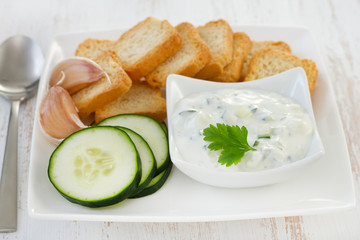 cucumber dip in bowl with toasts