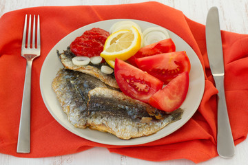 fried filet of sardines with onion and tomato