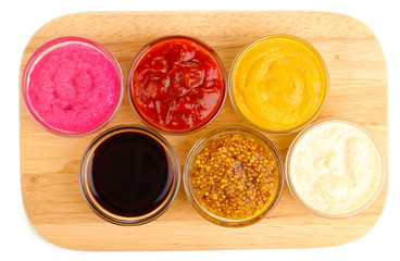 various sauces on chopping board isolated on white